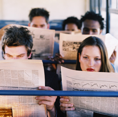 high angle view of people in a commuter vehicle reading the newspaper